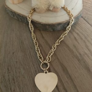"Collier doré avec pendentif cœur martelé, un bijou chic et intemporel."