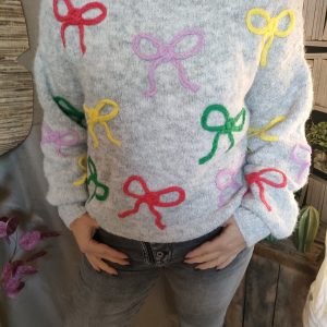 "Pull tricoté doux et original, agrémenté de nœuds colorés pour un style pétillant et tendance."